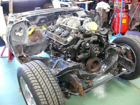Engine and front chassis of a classic car project, with suspension and tire.