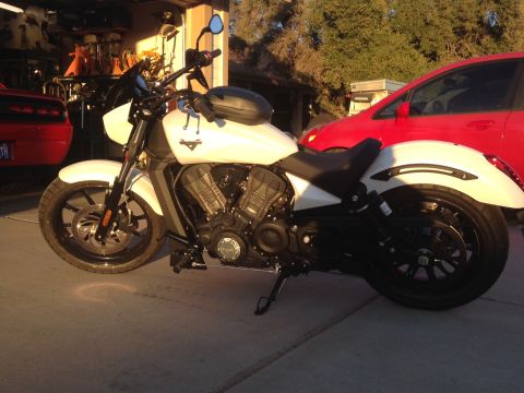 2010 Dodge Challenger - A white Victory motorcycle is parked on a concrete driveway in front of a red Dodge Challenger. The motorcycle is viewed from the side, sho…