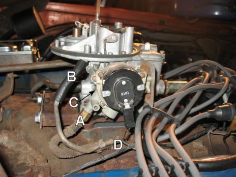 1978 Ford Bronco - A close-up view of a carburetor and distributor assembly on a V8 engine. Several spark plug wires are visible, along with various hoses and…