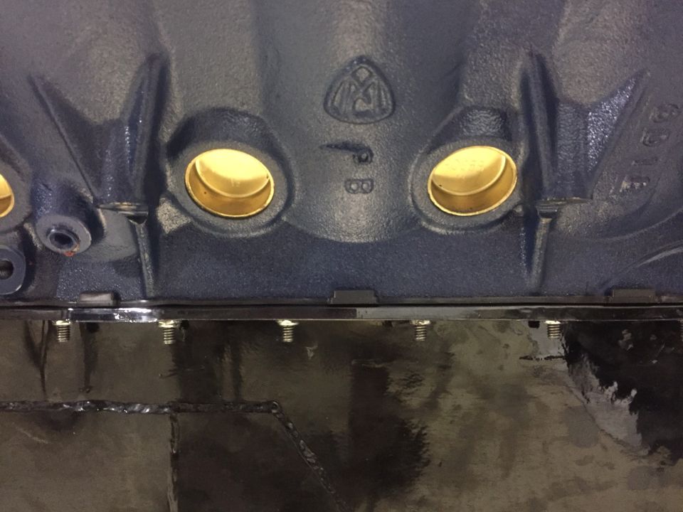 Close-up of engine block main bearing journals with brass inserts and PB stamp.