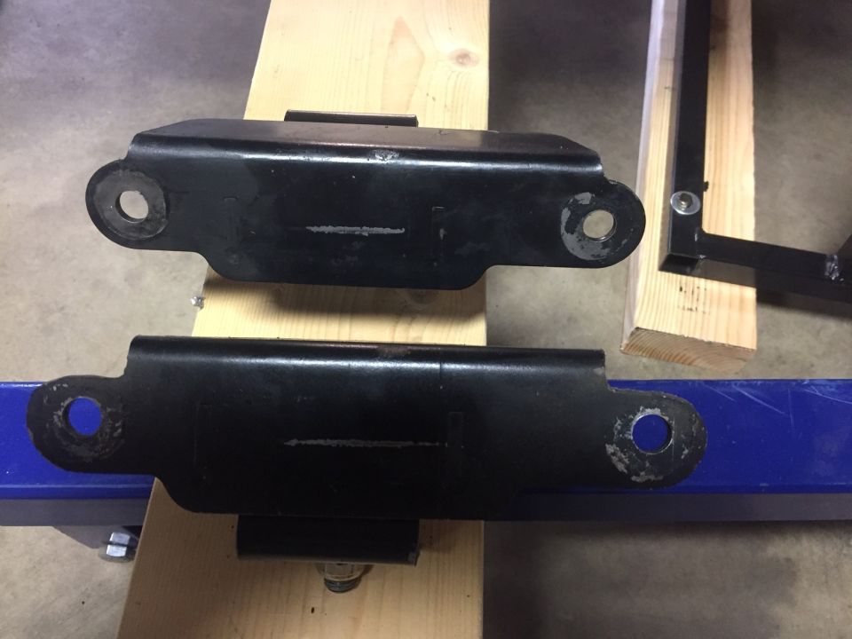 Two black metal brackets with circular mounting holes.