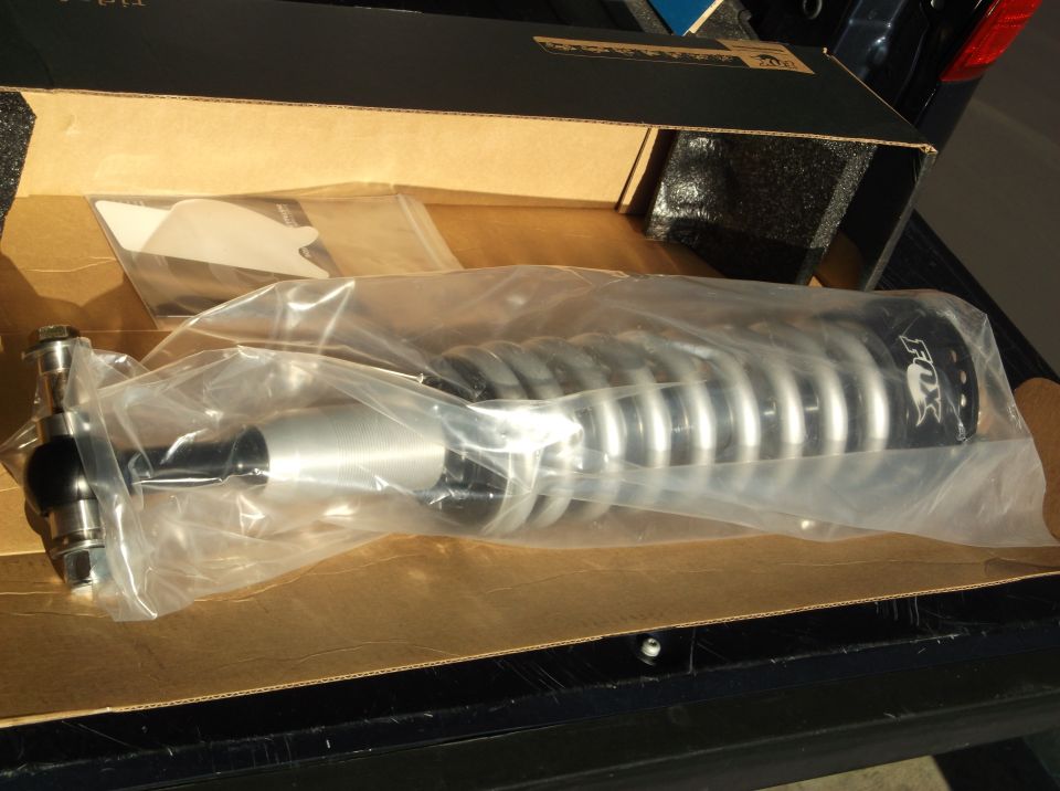 New FOX shock absorber with silver coilover spring in packaging.