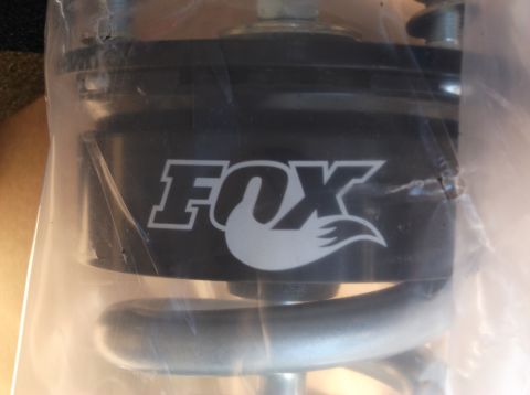2005 Ford F-150 - A close-up shot shows a black suspension component with the white "FOX" logo and a stylized fox tail. The part is partially covered by clea…