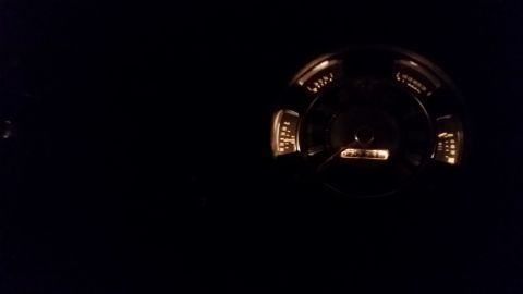 1973 Ford Bronco - A close-up view of a car's illuminated dashboard gauge cluster at night.