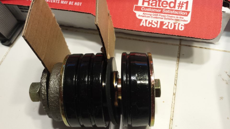 Pair of black rubber suspension bushings with metal inserts and bolts
