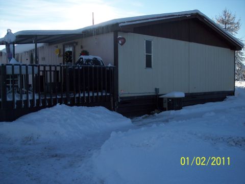 1989 Ford Bronco - A mobile home sits covered in snow with icicles hanging from the roof and deck.