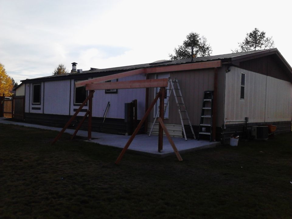 Construction scene with wooden frame and ladders against a mobile home