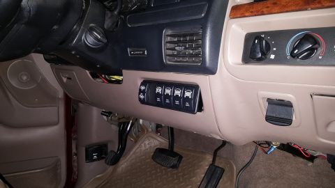 1996 Ford Bronco - A close-up view of the interior dashboard of a 1996 Ford Bronco, showing a custom-installed switch panel with labels for various lights and…