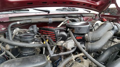 1996 Ford Bronco - The interior of a Ford Bronco engine bay, featuring a maroon exterior paint color and a close-up view of the engine components. Visible par…