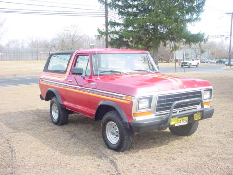 1979 Ford Bronco - This red Ford Bronco has a black hardtop and distinctive side stripes.