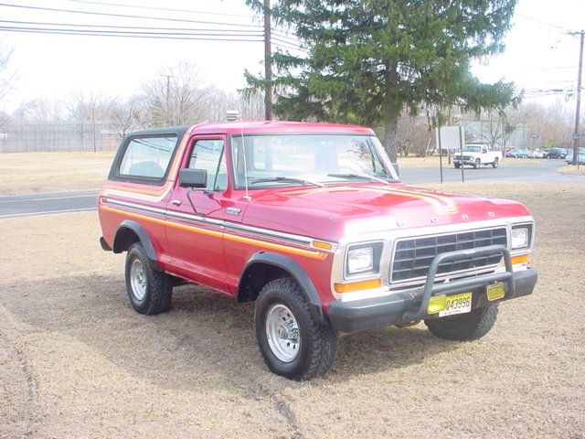 Red 1978 Ford Bronco with a black hardtop and side stripes