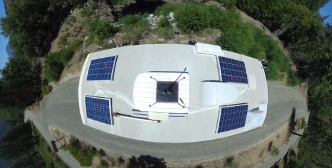 1995 Chevrolet P30 1 Ton - Step Van - An overhead view of the roof of a white step van, featuring multiple solar panels, an air conditioning unit, and a vent. The vehicle is par…
