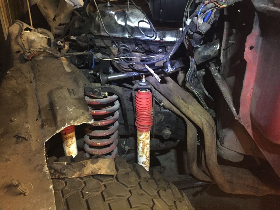 Close-up of engine bay and front suspension of a classic Ford Bronco.