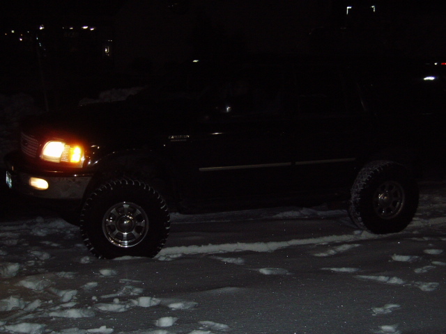 Black 1998 Ford Expedition with lifted suspension and off-road tires parked in snow