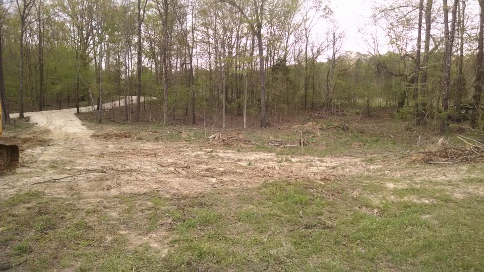 The guy who built the driveway did the initial clearing for the shop, but he left some stumps and debris, and he didn't level it so there are some mud pits now.