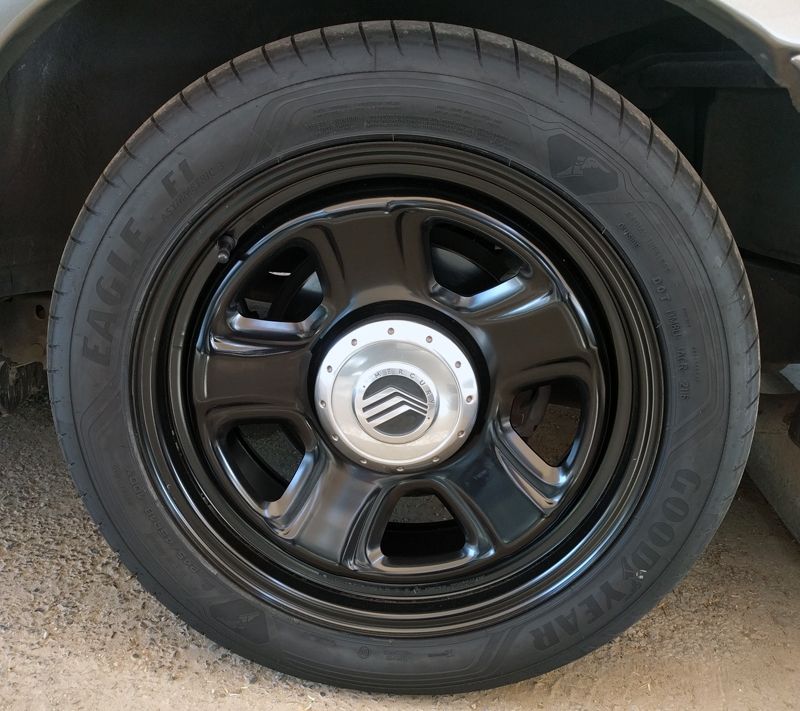 Gloss black five-spoke wheel with Mercury center cap and Goodyear Eagle F1 tire