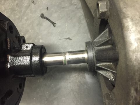 1988 Ford Bronco - A close-up view shows a metal shaft connecting two black mechanical components, likely part of a vehicle's drivetrain. The shaft is shiny a…