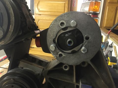 1988 Ford Bronco - A close-up view shows a metallic component with several bolts, likely part of an engine or accessory system, mounted onto a larger bracket.…