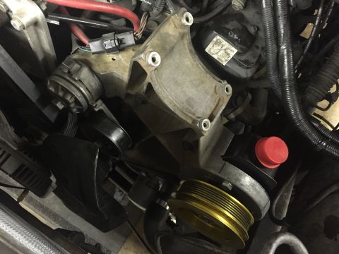 1988 Ford Bronco - Close-up view of the engine bay of a 1988 Ford Bronco, focusing on the serpentine belt system and power steering pump. A gold-colored pulle…