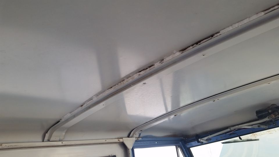 Interior headliner of a vehicle with visible rust and water damage along support beams.