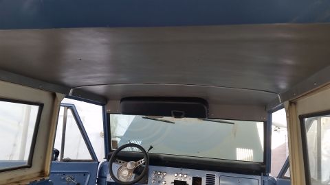 1973 Ford Bronco - Interior view of a vintage Ford Bronco, showing the headliner, dashboard, steering wheel, and windshield.