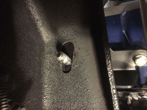 1982 Ford Bronco - A close-up view of a threaded metal fitting protruding from a textured, dark-colored surface, likely part of a vehicle's undercarriage or e…