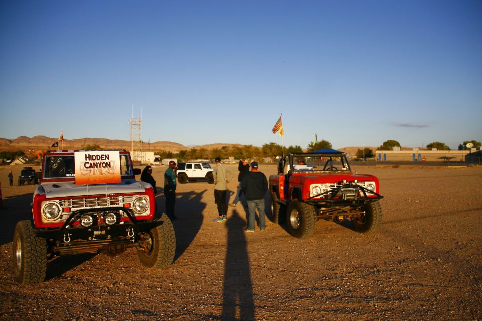 Two off-road Ford Broncos parked on a dirt lot.