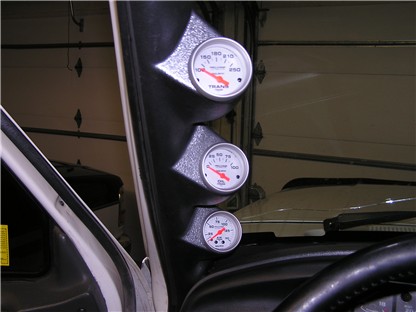 1993 Ford Bronco - A set of three aftermarket gauges are installed on the A-pillar of a vehicle's interior.