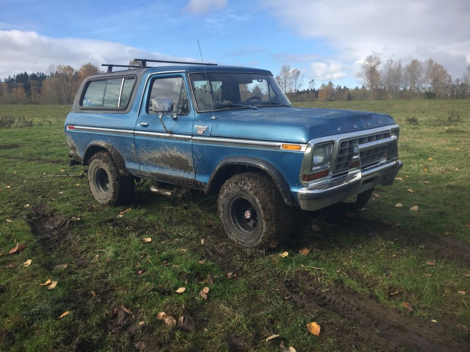 Blue 1979 Ford Bronco in a muddy field