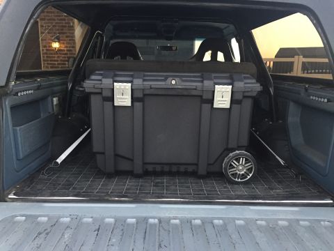 1988 Ford Bronco - Cargo area of a 1988 Ford Bronco, fitted with a large, wheeled storage container.