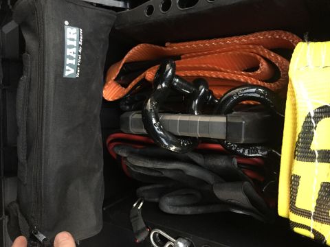 1988 Ford Bronco - Vehicle recovery gear including a Viair bag, tow strap, and shackles is stored in a compartment.