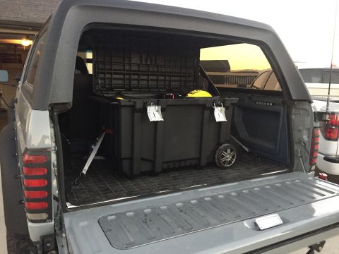 1988 Ford Bronco - Rear view of a 1988 Ford Bronco showing the cargo area with a large storage container inside.