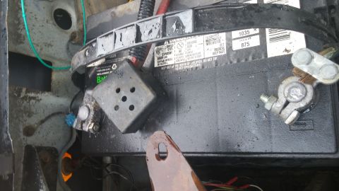 1984 Ford Bronco - A vehicle battery is shown with its terminals and surrounding engine bay components.