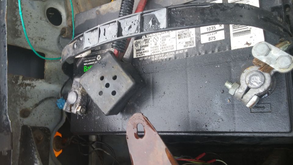 Close-up of a car battery with terminals and some wiring