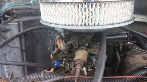 1984 Ford Bronco - Close-up view of an engine's carburetor and air filter assembly.