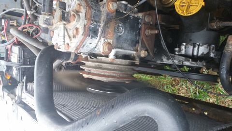 1984 Ford Bronco - Close-up view of an engine's compressor and pulley system, with visible hoses and wiring.