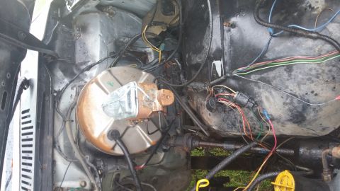 1984 Ford Bronco - Close-up of the engine bay wiring and brake booster, showing various wires and connections.