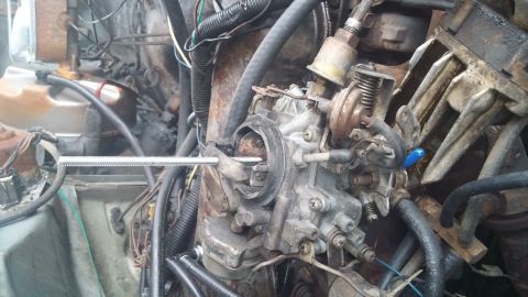 1984 Ford Bronco - Engine bay detail showing a carburetor and associated plumbing, likely undergoing maintenance.