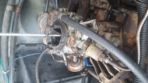 1984 Ford Bronco - This image shows a close-up view of a vehicle's carburetor and surrounding engine components.
