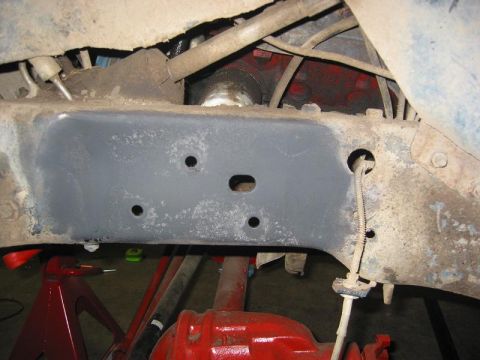 1985 Ford Bronco - Close-up of a vehicle's undercarriage, highlighting a solid axle swap modification with visible suspension parts and wiring.