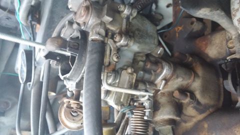 1984 Ford Bronco - Engine bay detail showing a carburetor assembly with various hoses and electrical connections.