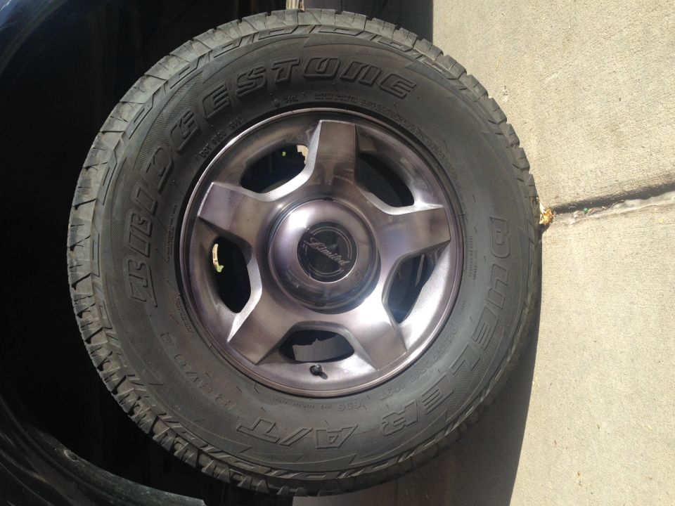 Spare tire with Bridgestone Dueler A/T radial tire on a five-spoke alloy wheel with a 'Limited' center cap