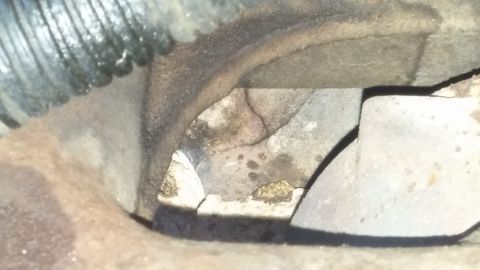 1984 Ford Bronco - Close-up view of engine components, showing various metal parts and some grime.