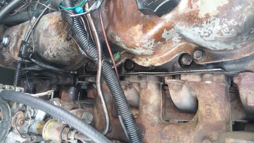 Engine manifold and hoses with visible rust and wear