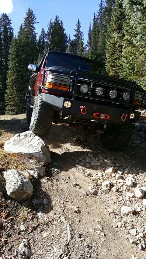 1996 Ford Bronco - This modified SUV navigates a rocky trail in a wooded area.