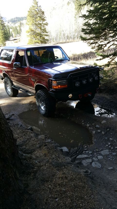 1996 Ford Bronco - This 1996 Ford Bronco navigates a muddy trail in a wooded area.