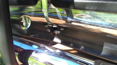 1996 Ford Bronco - A close-up view of a vehicle's chrome push bar, showing its mounting hardware and reflections.