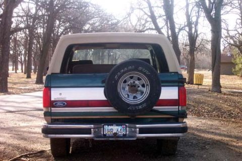1987 Ford Bronco - This 1987 Ford Bronco features a two-tone paint scheme and a rear-mounted spare tire.