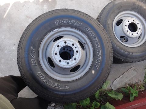 1995 Chevrolet P30 1 Ton - Step Van - Two Toyo Open Country H/T tires mounted on eight-lug silver steel wheels resting on a concrete surface.