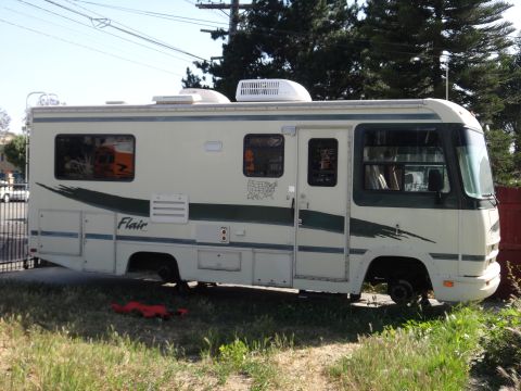 1995 Chevrolet P30 1 Ton - Step Van - This RV, labeled "Flair," is seen from the side, with its wheels removed.